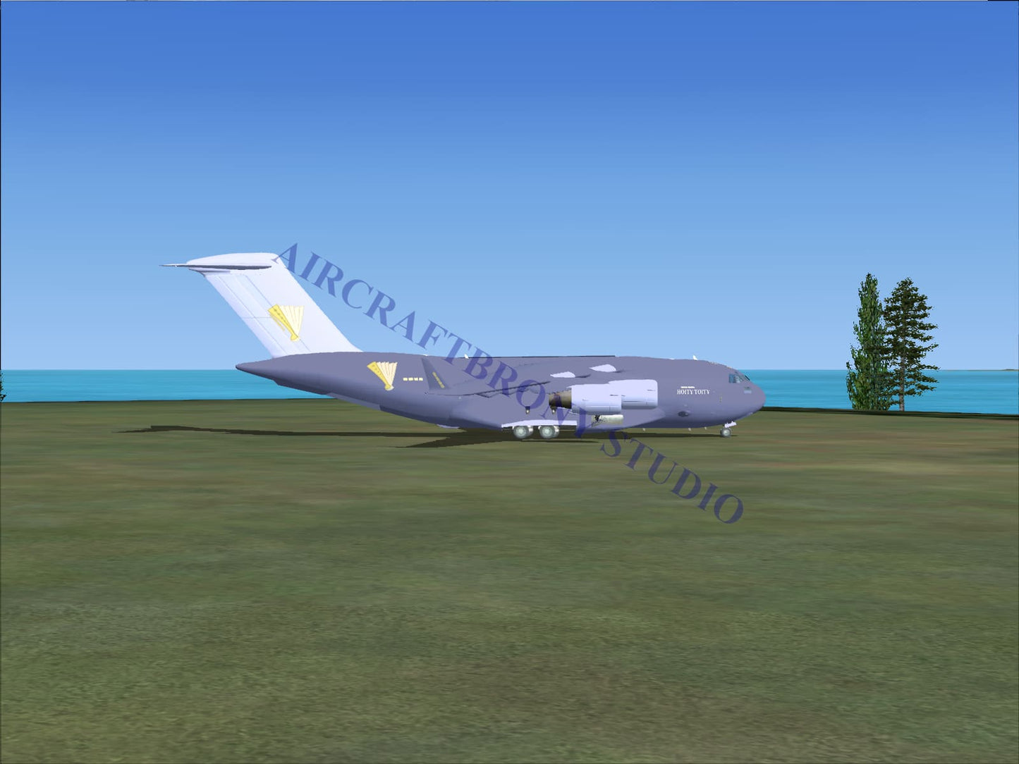 Gray hoity toity boeing c-17 military transport aircraft with yellow insignia and four jet engines digital image